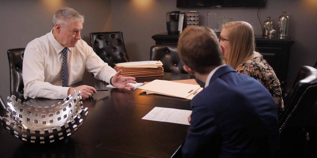 Kelly Fowler, attorney at law, in a meeting discussing legal matters with two clients in an office.